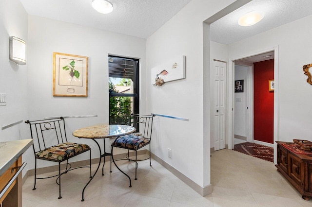 dining area with a textured ceiling and baseboards