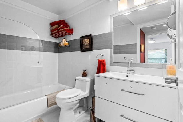 full bathroom featuring shower / washtub combination, vanity, toilet, and tile walls