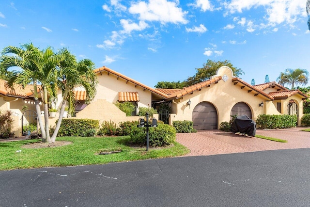 mediterranean / spanish-style house featuring a garage and a front yard