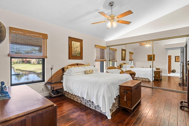 bedroom featuring dark wood finished floors, ceiling fan, vaulted ceiling, a textured ceiling, and a closet