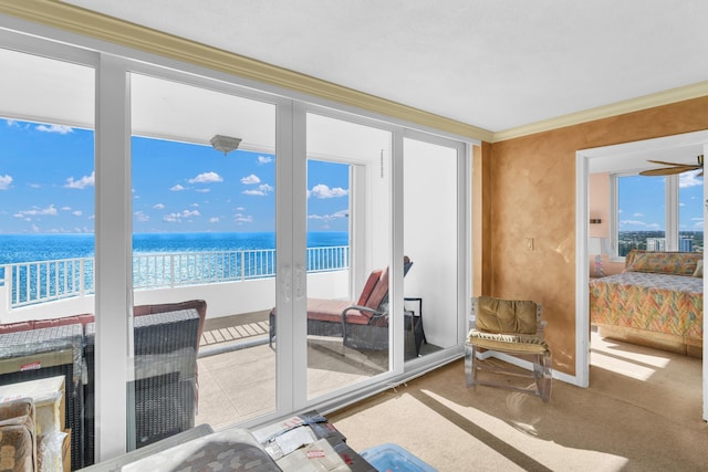 sunroom with a water view and a beach view