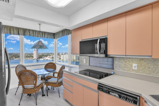 kitchen featuring dishwasher, freestanding refrigerator, black electric stovetop, light countertops, and backsplash