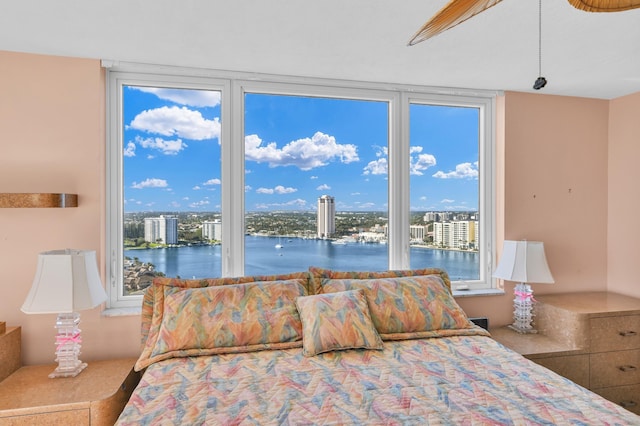 bedroom featuring a view of city and a water view