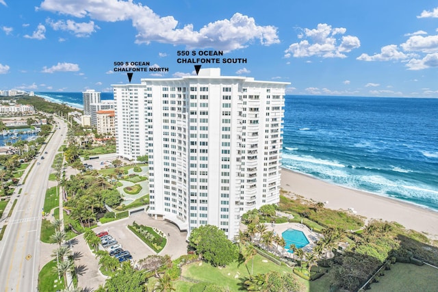 birds eye view of property featuring a water view and a beach view