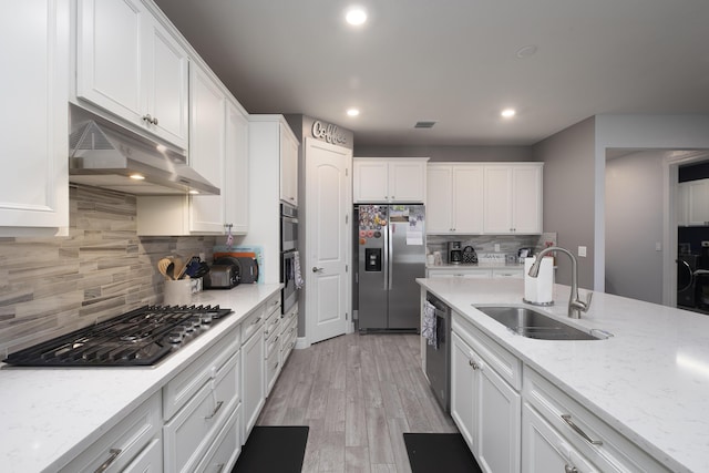 kitchen featuring white cabinetry, appliances with stainless steel finishes, sink, and light stone counters