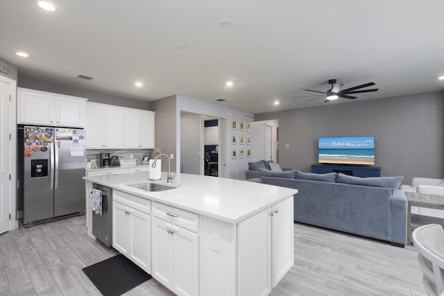 kitchen featuring white cabinetry, appliances with stainless steel finishes, sink, and a center island with sink