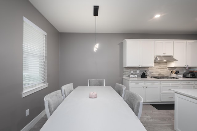 kitchen featuring white cabinetry, decorative light fixtures, decorative backsplash, and stainless steel gas stovetop