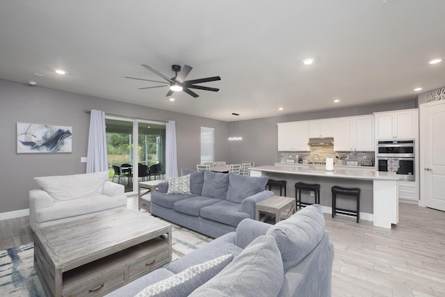 living room with light hardwood / wood-style floors and ceiling fan