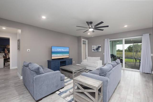 living room featuring ceiling fan and light hardwood / wood-style floors