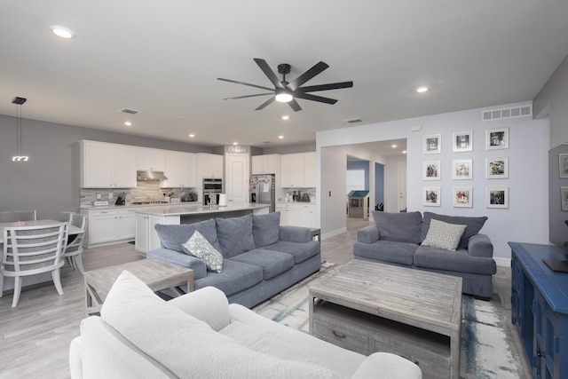 living room with ceiling fan and light wood-type flooring