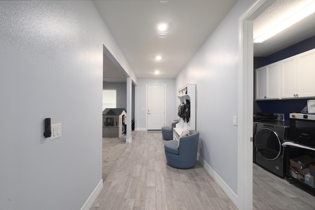 hall with washer and clothes dryer and light wood-type flooring