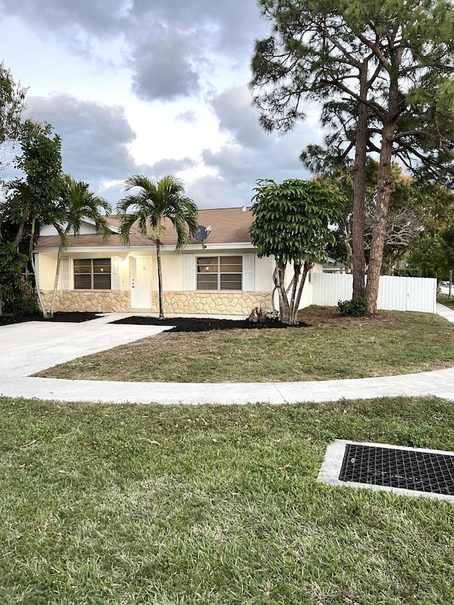 single story home featuring a front lawn