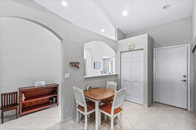 dining room featuring lofted ceiling and light tile patterned floors