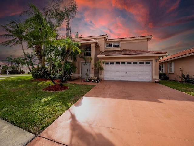 mediterranean / spanish-style home featuring a yard and a garage