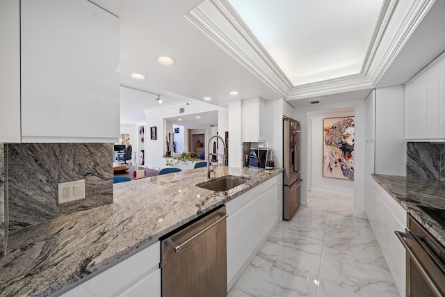 kitchen featuring sink, stainless steel appliances, light stone counters, white cabinets, and a raised ceiling