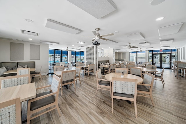 dining area featuring floor to ceiling windows, ceiling fan, and light wood-type flooring