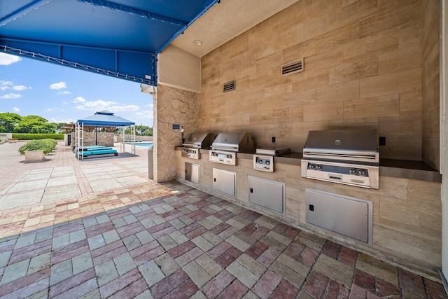 view of patio / terrace featuring a grill, a gazebo, and exterior kitchen