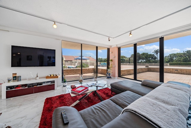 living room with track lighting, floor to ceiling windows, and a textured ceiling