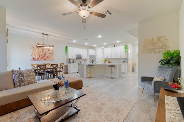 living room featuring ceiling fan and light wood-type flooring