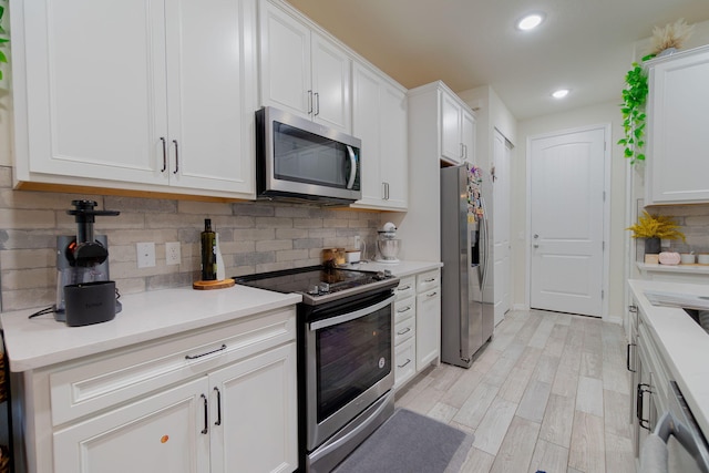 kitchen with tasteful backsplash, white cabinets, and appliances with stainless steel finishes