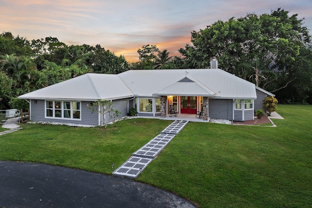 ranch-style home featuring a lawn