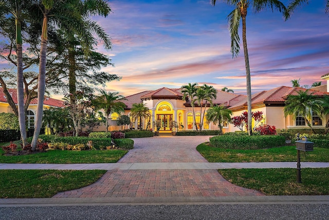 mediterranean / spanish-style house with a lawn