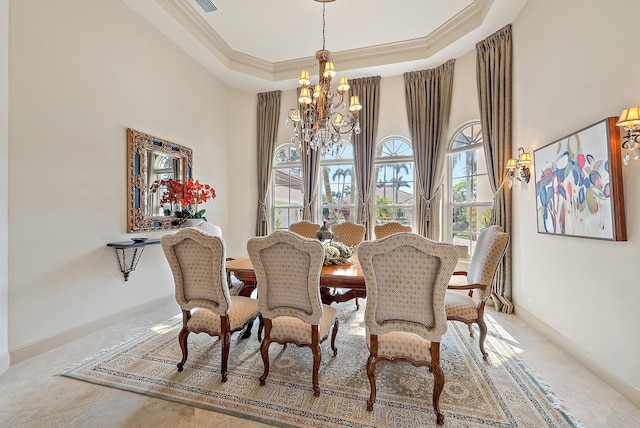 dining area featuring crown molding, a raised ceiling, a chandelier, and a towering ceiling