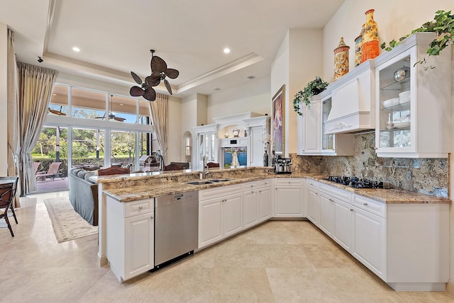 kitchen featuring a raised ceiling, dishwasher, sink, and kitchen peninsula