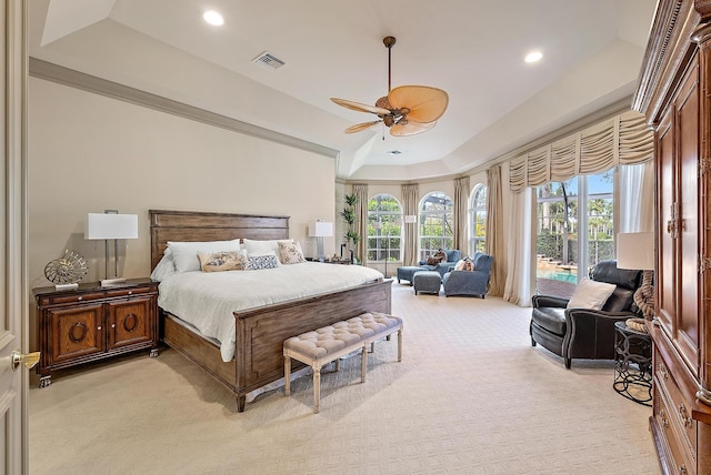 bedroom with access to outside, light colored carpet, a raised ceiling, and ceiling fan