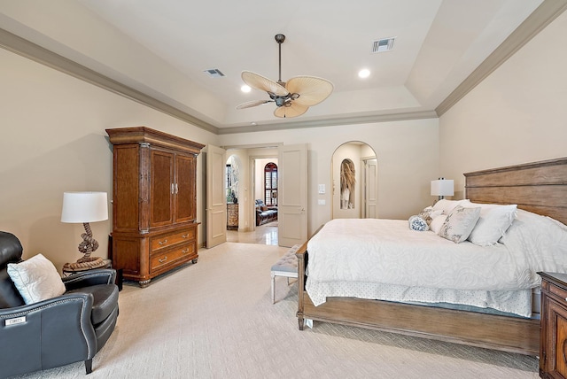 bedroom featuring ceiling fan, light colored carpet, a tray ceiling, and crown molding