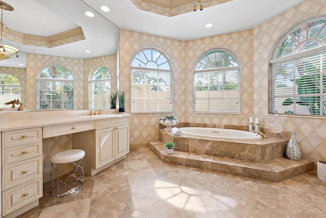 bathroom featuring tiled tub, vanity, a wealth of natural light, and tile walls