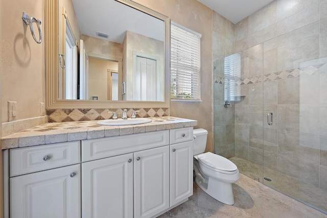 bathroom featuring vanity, decorative backsplash, a shower with shower door, and toilet