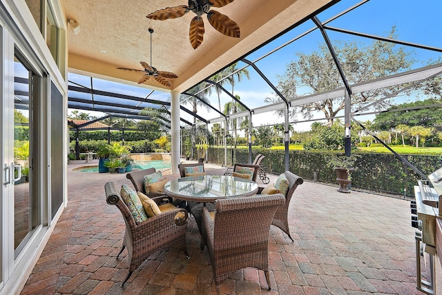 view of patio featuring a water view, ceiling fan, and glass enclosure