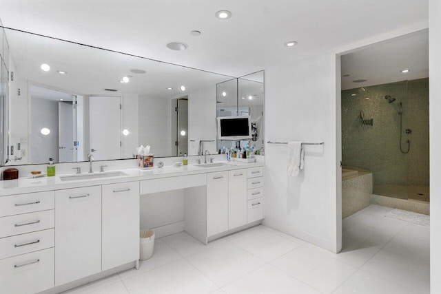 bathroom featuring tiled shower, vanity, and tile patterned flooring