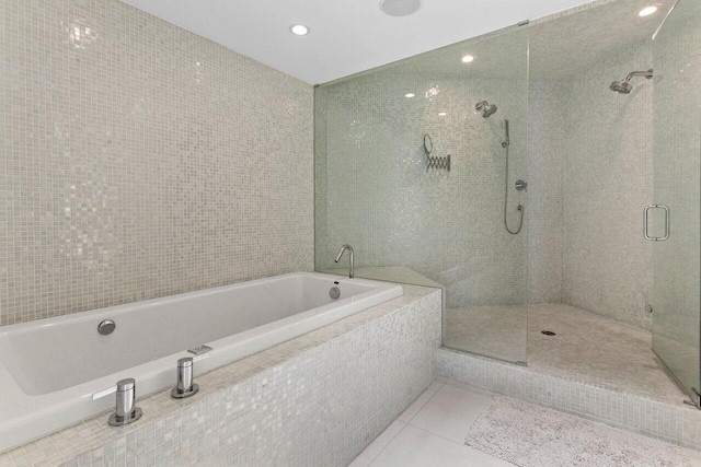 bathroom featuring tile patterned floors, a tile shower, tile walls, and a garden tub