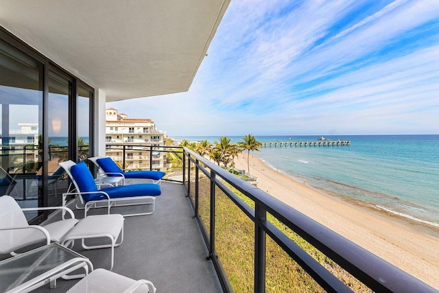 balcony with a water view and a beach view