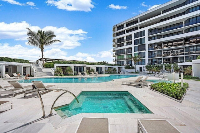 view of swimming pool with a hot tub and a patio