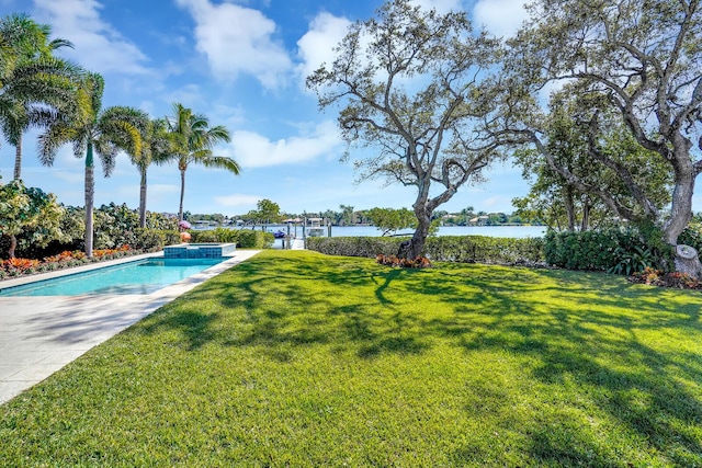 view of swimming pool featuring a yard and a water view