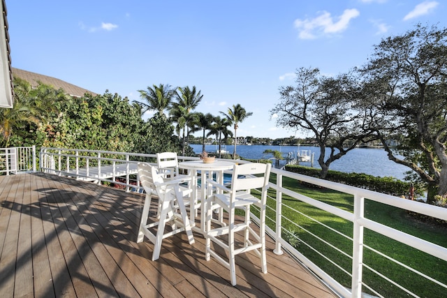 deck featuring a water view and a lawn