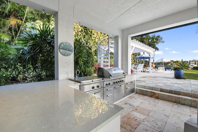 view of patio featuring exterior kitchen, grilling area, and a pergola