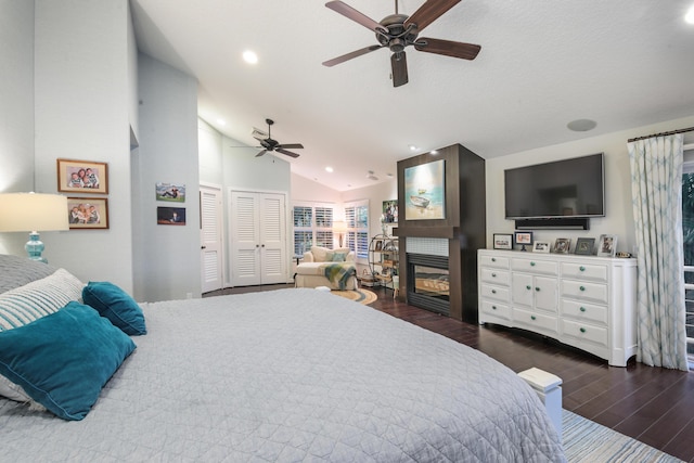 bedroom with ceiling fan, dark wood-type flooring, a textured ceiling, and lofted ceiling