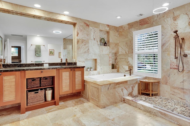 bathroom with plus walk in shower, vanity, and tile walls