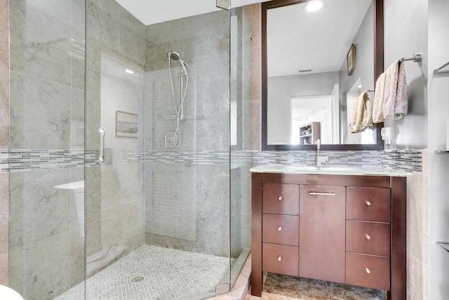 bathroom featuring vanity, walk in shower, and decorative backsplash