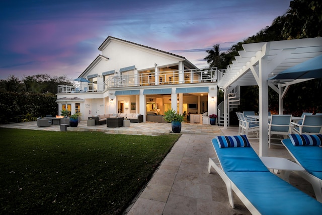 rear view of house with an outdoor living space, a pergola, a lawn, a balcony, and a patio area