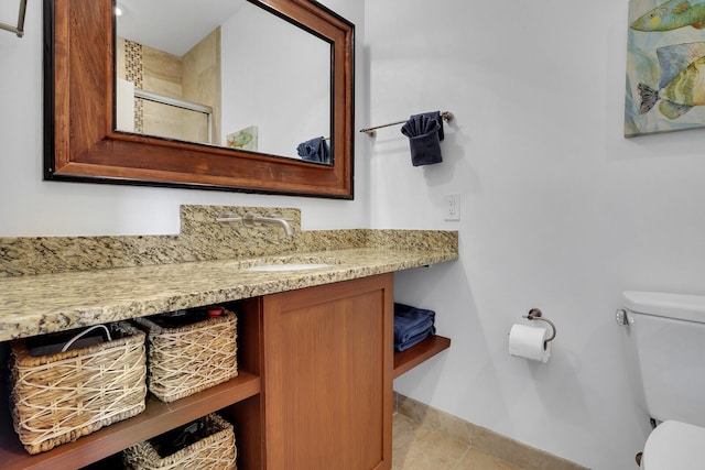 bathroom featuring toilet, a shower with shower door, and vanity