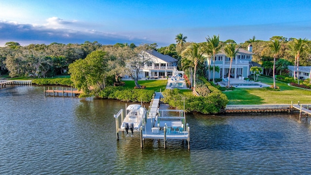 view of dock with a water view and a yard