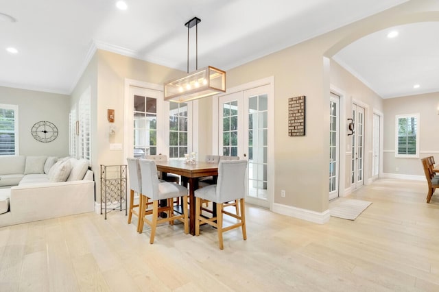 dining space with light hardwood / wood-style flooring, crown molding, french doors, and a healthy amount of sunlight