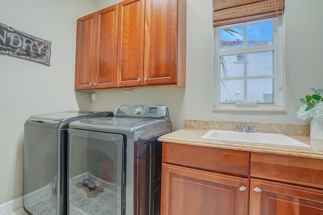 washroom with washing machine and dryer, cabinets, and sink