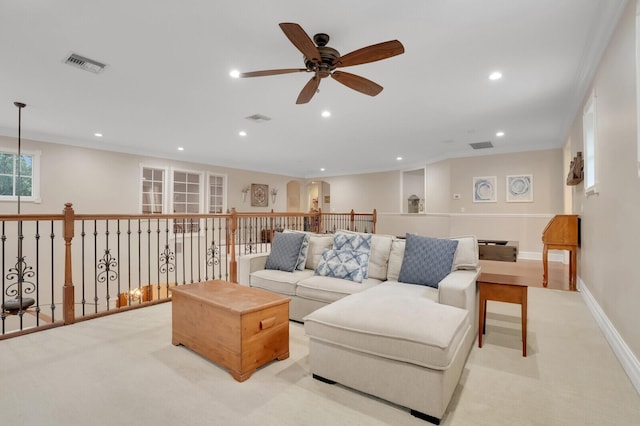 carpeted living room featuring ceiling fan and crown molding