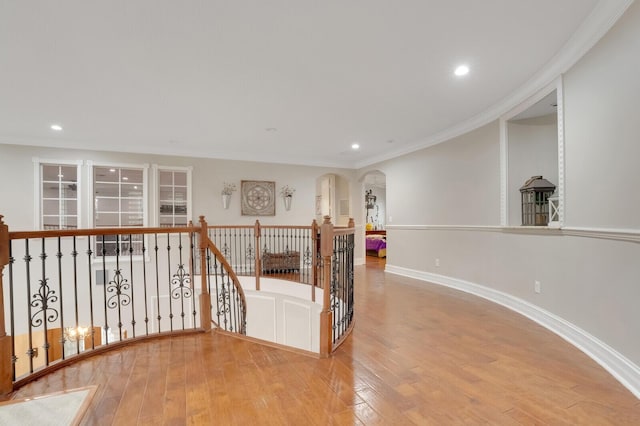 corridor with light wood-type flooring and ornamental molding